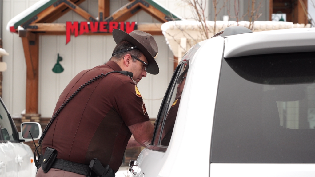 UHP Sgt. Lawrence Hopper issues a ticket to a driver for crossing the HOV lane’s solid, double white line.