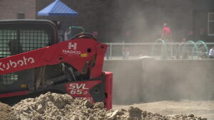 Construction workers outside the school grounds as kids play. (KSL TV)