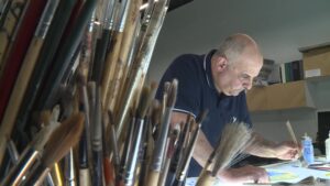 Ali Albaddah working on the mixture of Arabic calligraphy and stained glass art. (KSL TV)