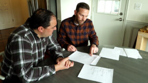 Andy Petersen shows KSL’s Matt Gephardt an insurance loss report detailing several claims he says he’s never made but are driving up his home and auto insurance prices. (Josh Szymanik, KSL TV)