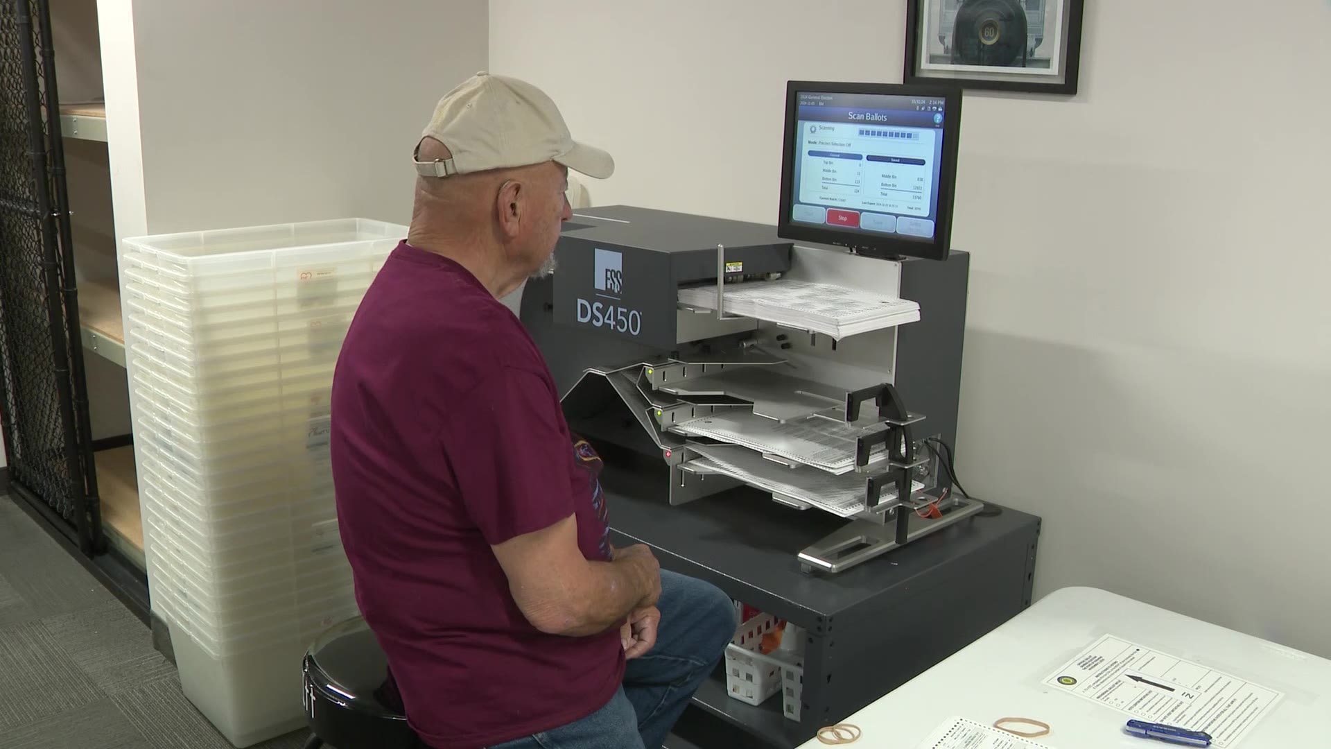 A poll worker feeding the ballots into the scanner. (KSL TV)