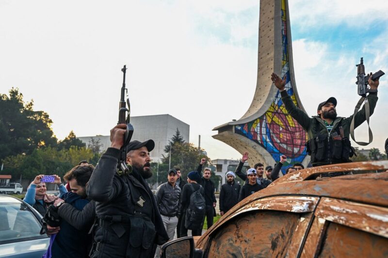 Anti-government fighters celebrate at Umayyad Square in Damascus on December 8. (Louai Beshara/AFP/Getty Images)