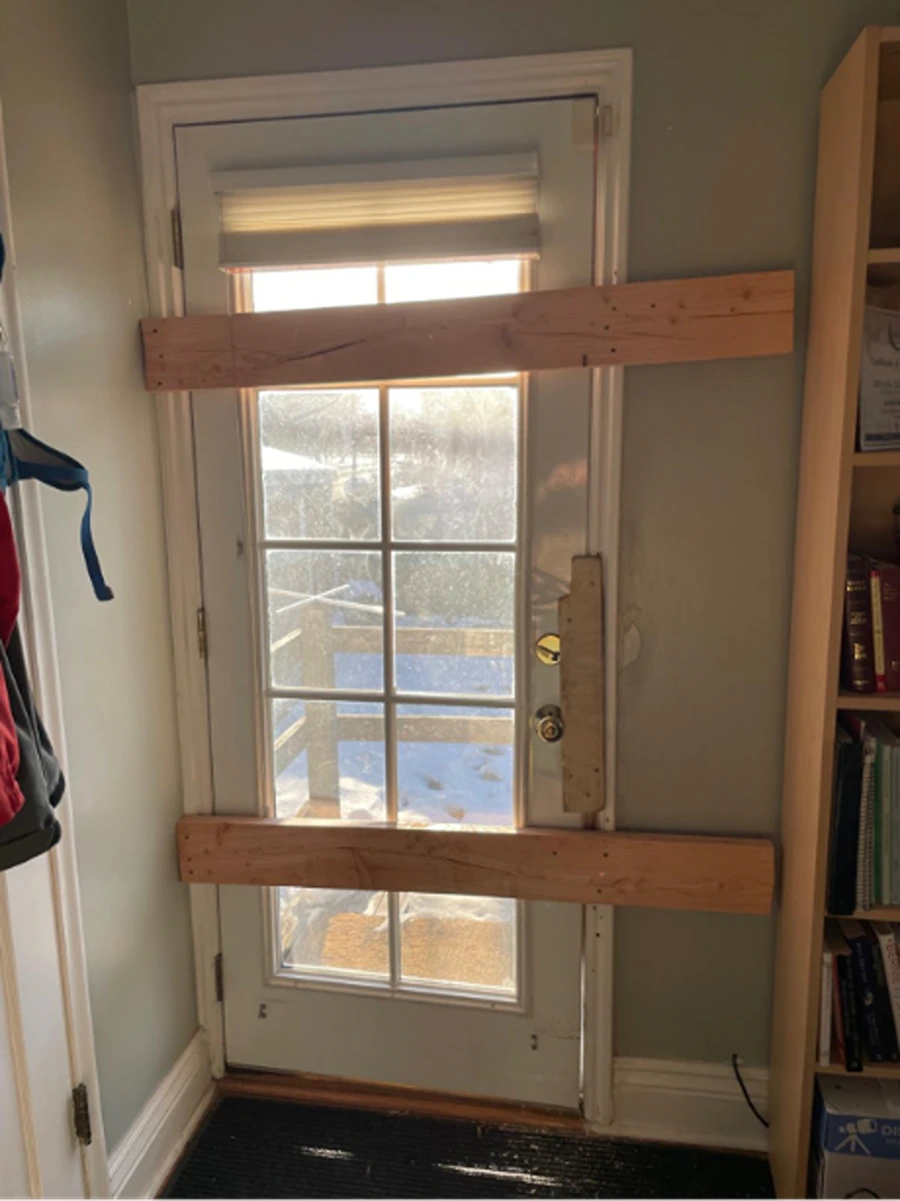 Door boarded up after stranger kicked it in (Zeb Pischnotte)