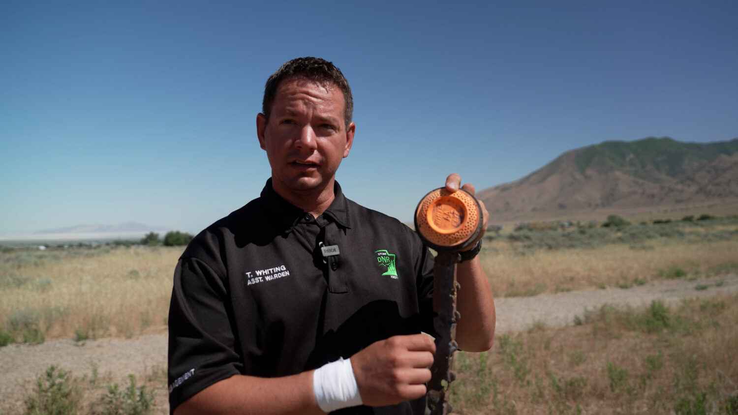 Tooele County Assistant Fire Warden, Trevor Whiting holds up a metal pole with multiple bullet holes in it as he says hot metal from it sparked a fire in 2024. (Photo courtesy: Forestry, Fire, and State Lands)