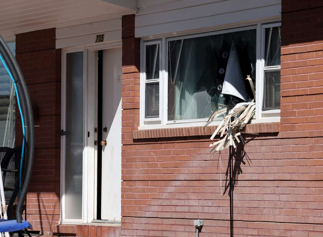 Broken out windows and an open door are seen at a home where three officers and a K-9 were shot Sunday night. The home waits for investigators to begin processing the evidence in Tremonton, Monday. (Brian Nicholson for the Deseret News)