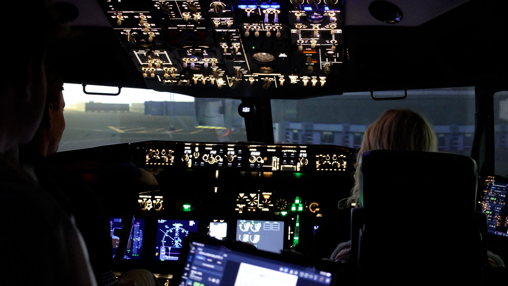 Students Ryan Peck (left) and Sydney Steed (right) get instruction from a volunteer graduate instructor inside a Boeing 737 simulator (Jack Grimm, KSL TV)