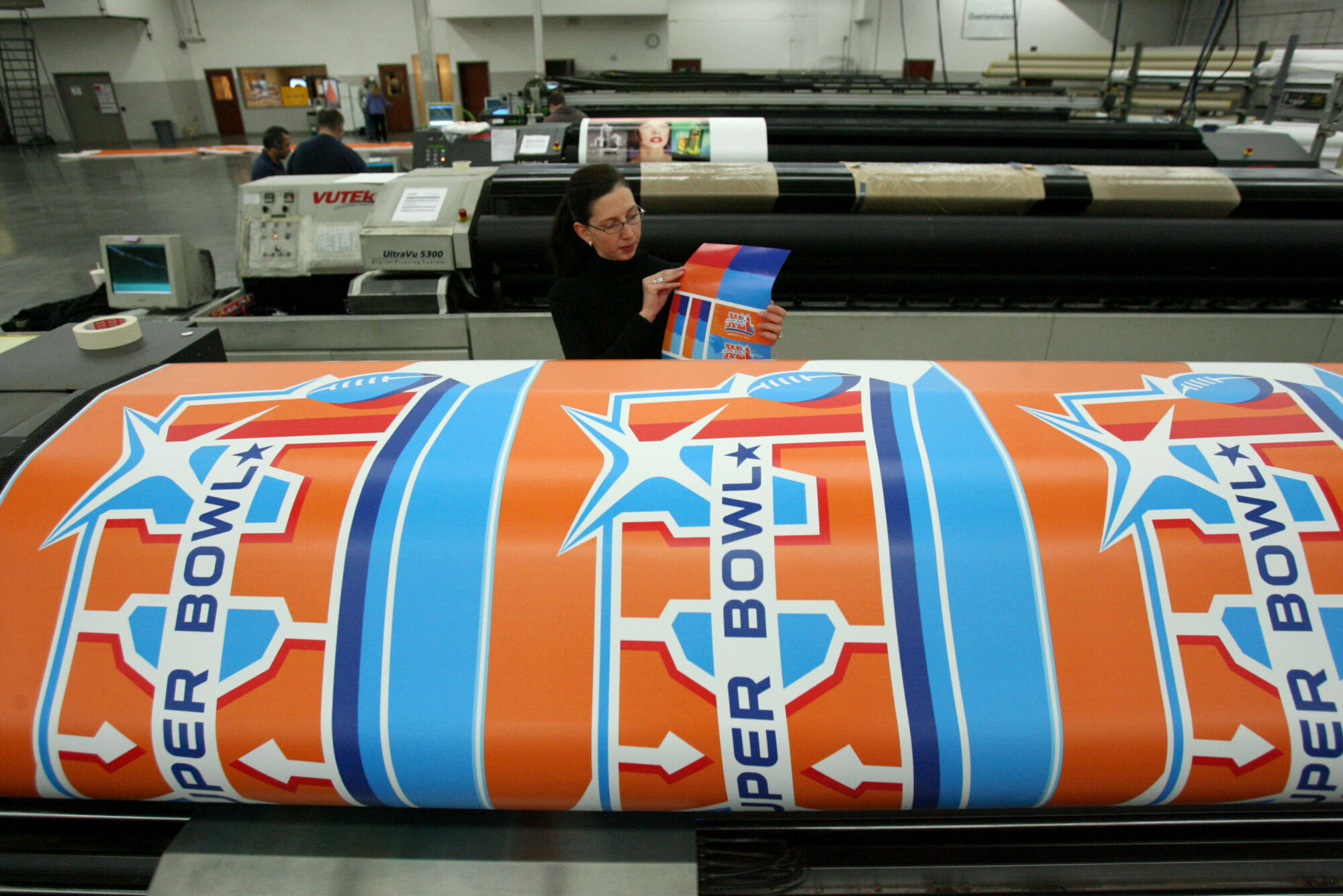Molly Mazzolini (Infinite Scale Design Group) looks over a color palette for the Super Bowl XLI wrap. The 225-foot High, 70-foot wide vinyl mesh Endzone Pylon Building Wrap will cover the NFL Headquarters in Miami at the Marriott. Michael Brandy. January 4, 2006. (Michael Brandy, Deseret News)