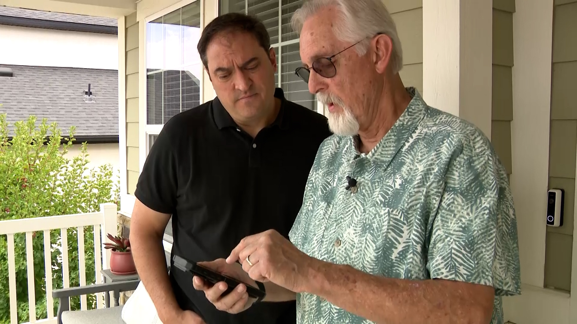 Philip Munoa shows KSL's Matt Gephardt the various photos he took after his car got hit by a rock he says was kicked up by a dump truck in front of him. (Stuart Johnson, KSL)