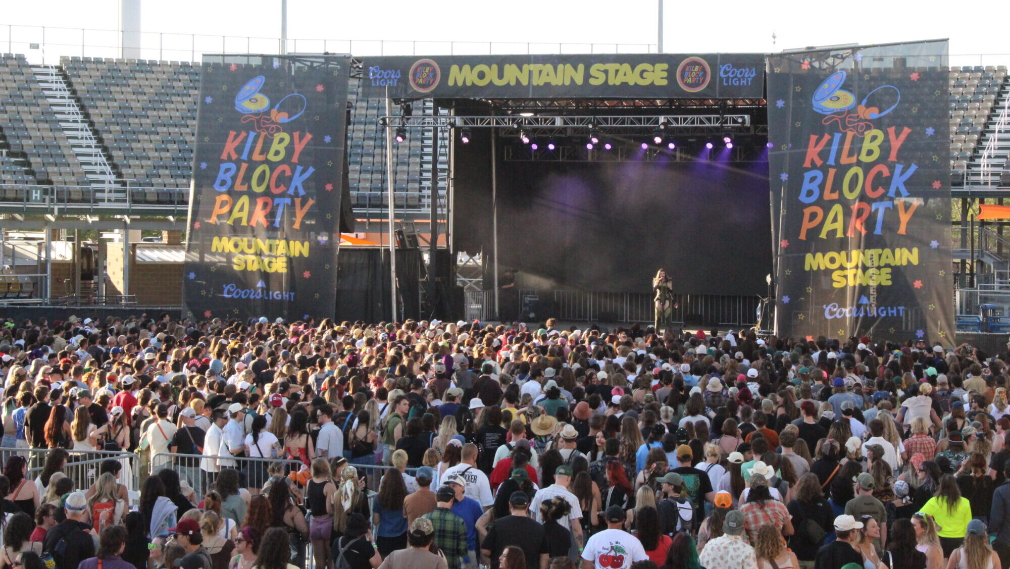A crowd gathers at the Mountain Stage at Kilby Block Part 7 as an emcee talks....